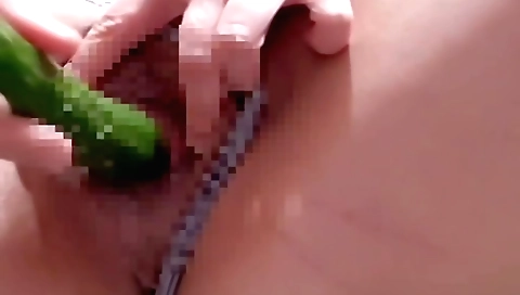 Amateur blonde masturbates with a cucumber on a bed