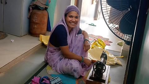 Indian girl uses a sewing machine to get ready for a job